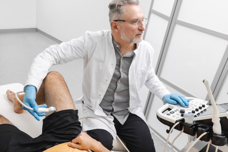 Medic face o ecografie la nivelul muschilor piciorului