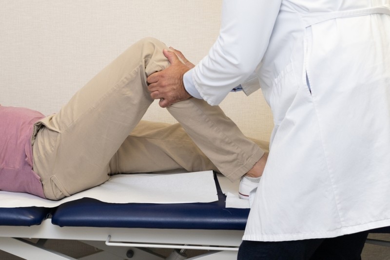 Un doctor ortoped face o evaluare a unui pacient cu dureri de genunchi